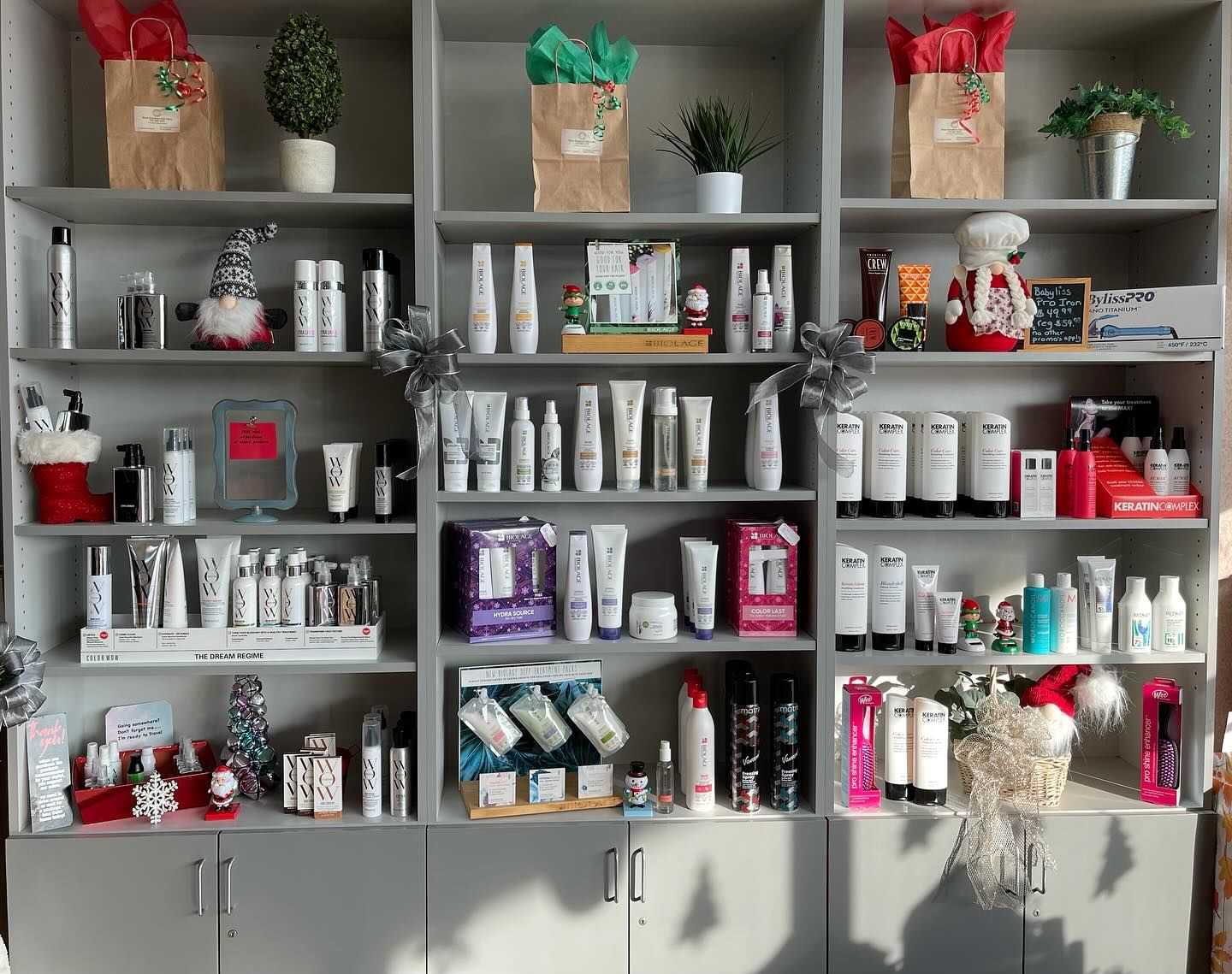 Shelves displaying various beauty and hair care products, some holiday-themed decorations.
